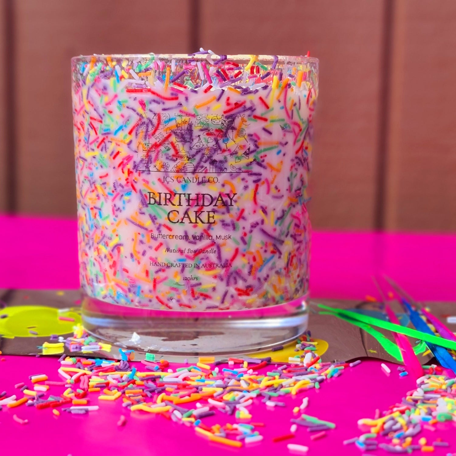 A colourful candle with sprinkles inside front facing